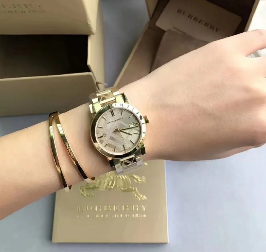 Front view of Burberry BU9033 unisex gold stainless steel watch with gold dial and minimalist design