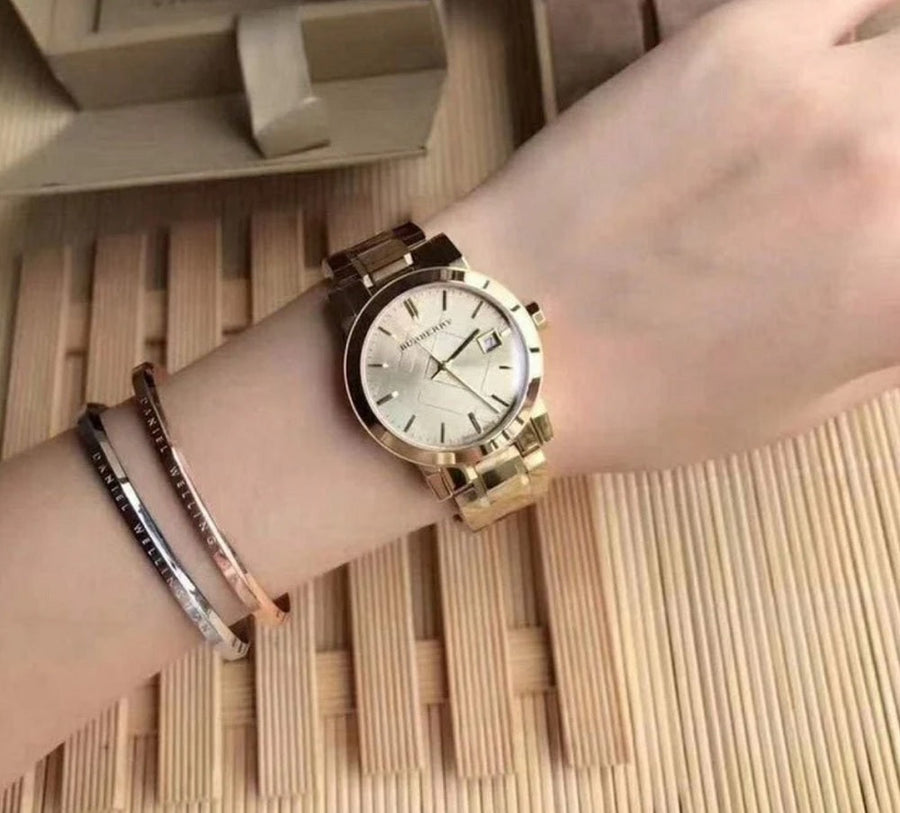 Front view of Burberry BU9134 women’s gold stainless steel watch with matching gold dial