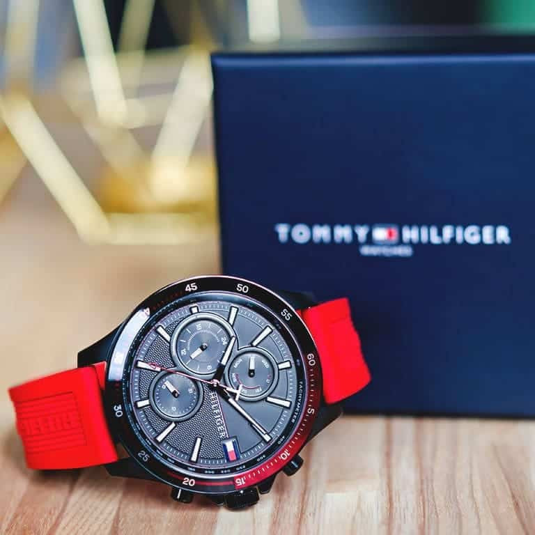 Close-up of Tommy Hilfiger 1791722 men’s watch featuring black dial, red silicone strap, and black case