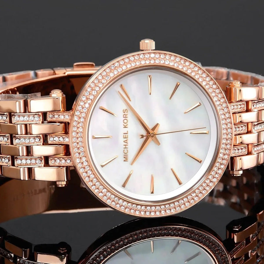Close-up of Michael Kors MK3220 mother of pearl dial, featuring crystal accents and signature MK branding