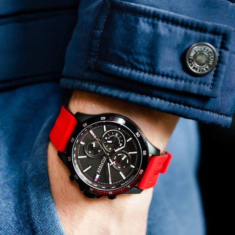 Close-up of Tommy Hilfiger 1791722 men’s watch featuring black dial, red silicone strap, and black case