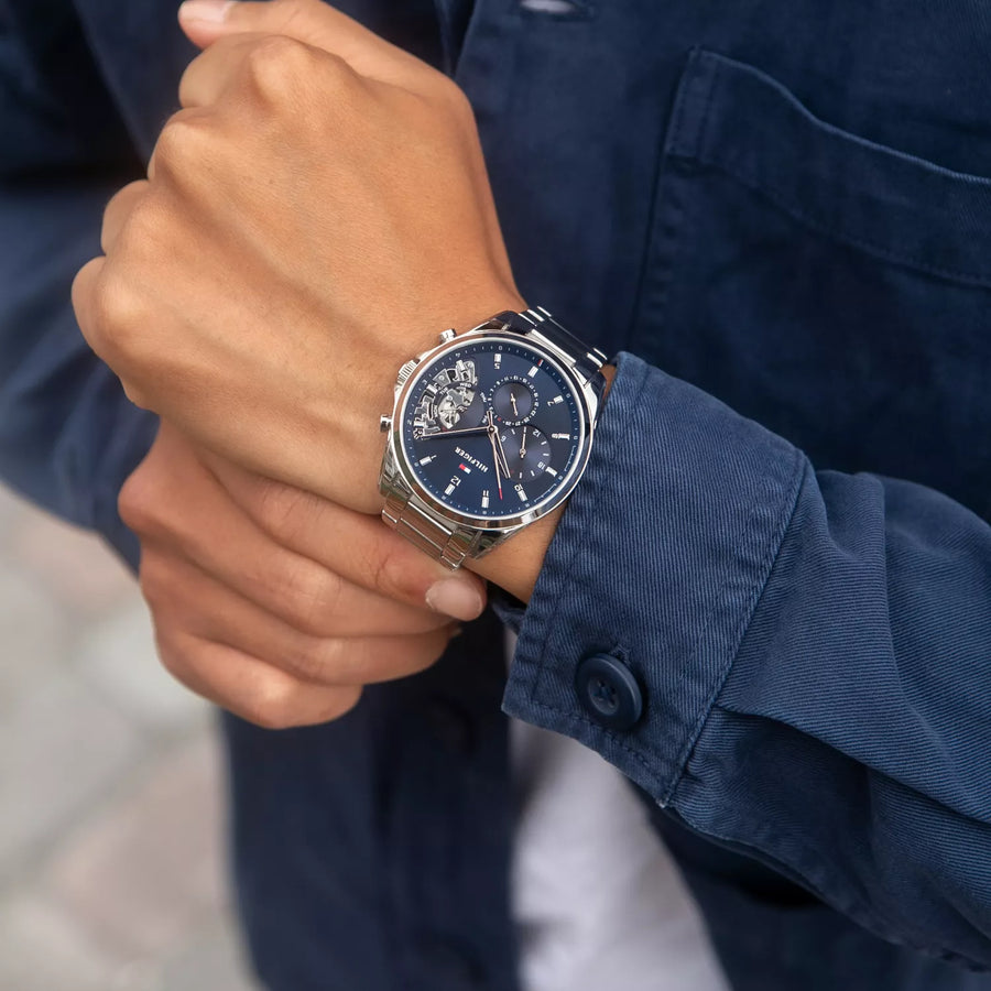 Tommy Hilfiger watch with blue dial and silver metal strap on a white background